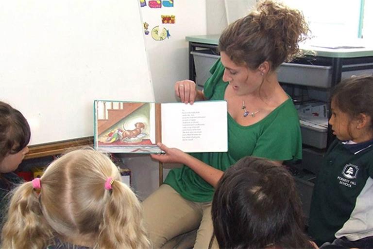 Teacher reading to a group of students as part of the Global Gateway program.