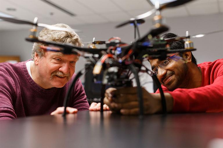 Student and instructor working on a drone.